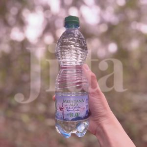 Hand holding up Montana Alps Natural Alkaline Mineral Water